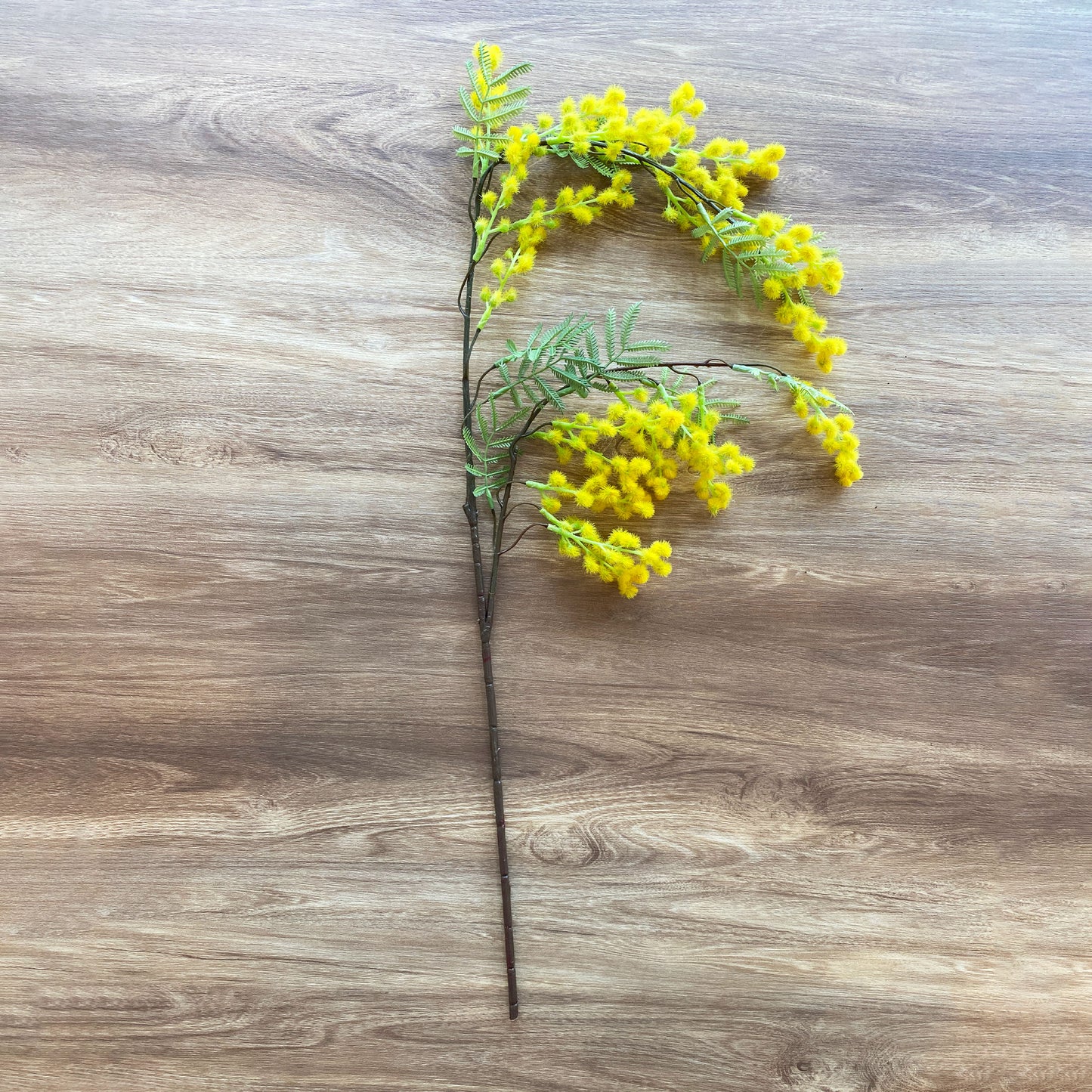 ミモザハンギング künstlicheの置き画。鮮やかな黄色の花が空間に彩りを添えます。