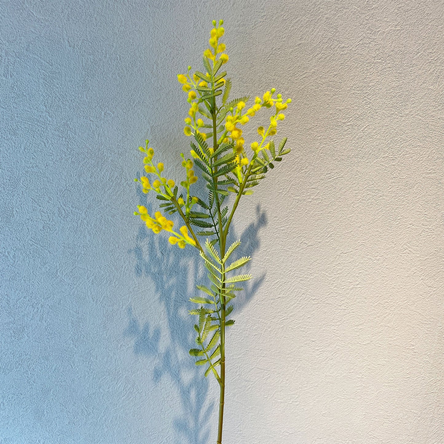 ミモザ künstlicheを手に持った写真。サイズ感やボリューム感がわかる構図。